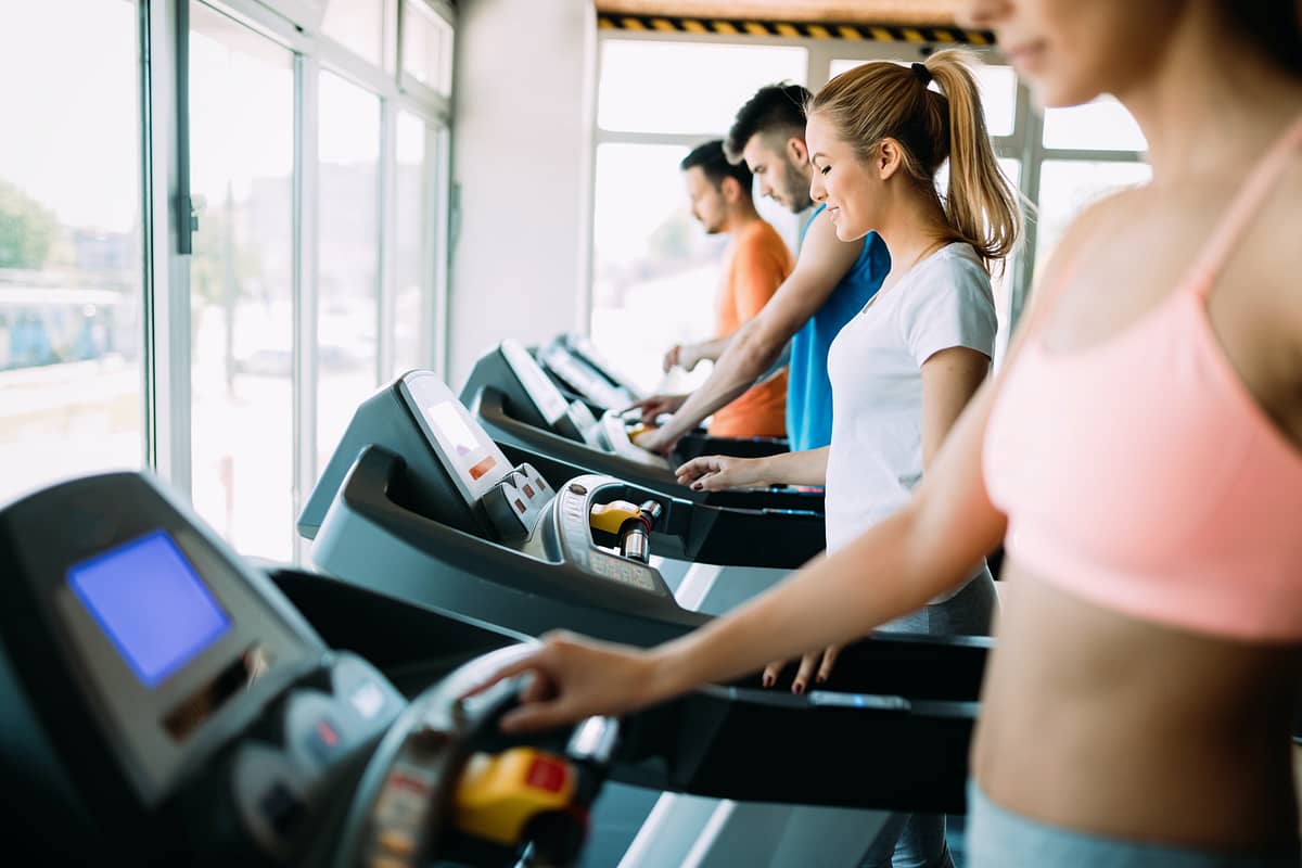 Happy people on treadmills in the gym